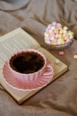 Bir fincan sıcak kahve, bir kitap ve tatlı şekerlemeler rahatlatıcı bir an için mükemmel.