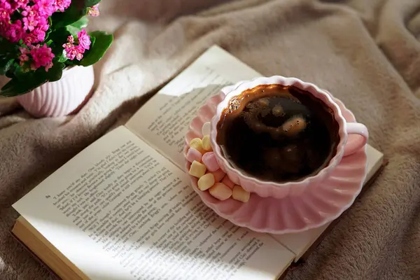 Bir fincan sıcak kahvenin, güzel bir kitabın ve huzurlu bir ortamda yumuşak marşmelovun tadını çıkar.