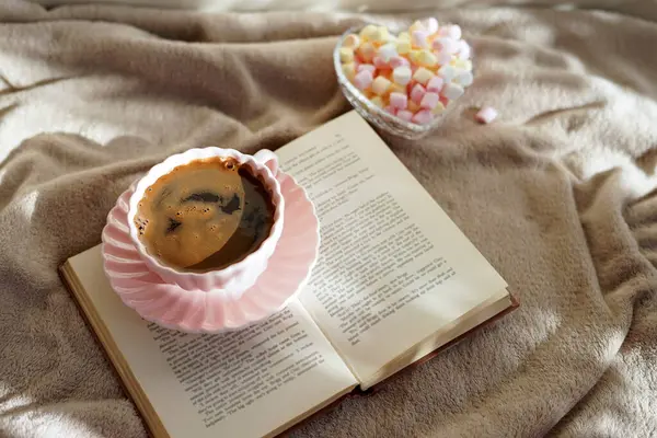 Bir fincan sıcak kahve, bir kitap ve tatlı şekerlemeler rahatlatıcı bir an için mükemmel.
