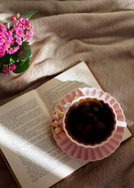 Bir fincan sıcak kahvenin, güzel bir kitabın ve huzurlu bir ortamda yumuşak marşmelovun tadını çıkar.