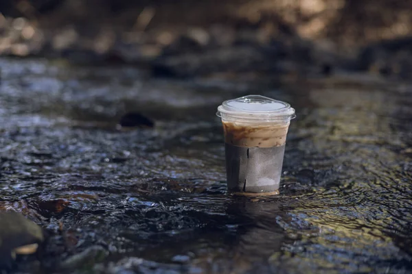 Iced coffee with nature view beside the stream