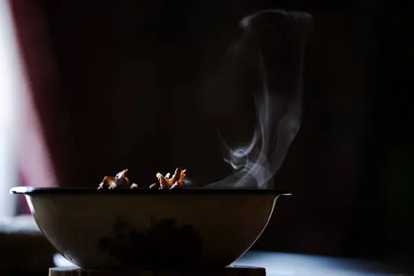 Sıcak yiyeceğin buharı tabağın üzerinden yükselir, açıkça karanlık arka planda görülür.,