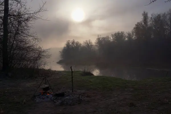 Güneş diski, sarp nehir kıyısında yoğun bir sis içinde yükseldi. Tek renkli manzara zıt yöndeydi.