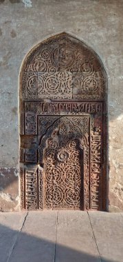 Duvar karmaşık tasarımlarla oyulmuş ve üzerinde bir sürü şekil var..