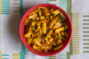 Close-up of Indian mango pickle in a red bowl, featuring vibrant colors and traditional spices, perfect for food photography, culinary blogs, or authentic Indian cuisine themes. clipart