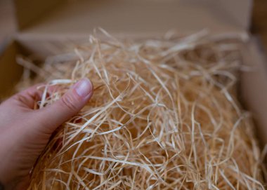 Çevre dostu paketleme konsepti. Online mağazalardan ve teslimatlardan gelen paketleri paketlemek için bir kutunun içinde parçalanmış kağıtların yakın plan görüntüsü. Ticaret ve çevresel etki.