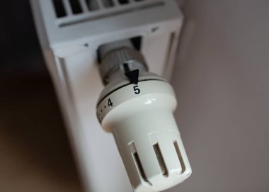  Radyatörün termostatik sıcaklık kontrol vanasını kapatın. Enerji verimliliği, sıcaklık düzenlemesi ve ev ısıtma kavramı.