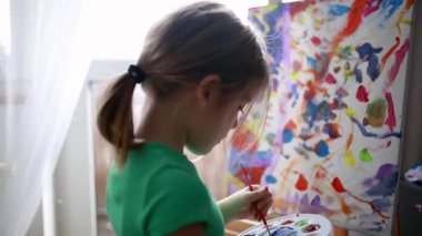 Şirin küçük kız sehpaya resim çiziyor. çocuk resimleri..