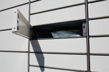  Paketi teslim edilmiş açık bir dolap hücresi. Güneş ışığı, metal inşaat, sipariş için modern paket dolabı. Online alışveriş ve lojistik kavramı.