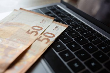 Laptop klavyesinde Euro banknotları. Nakit para, dijital ödemeler ve finansal işlemler kavramı. Yüksek kalite fotoğraf
