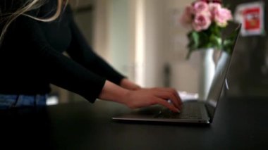 Serbest çalışan bir kadın dizüstü bilgisayarı kapatıyor ve ofisinden uzaklaşıyor. Uzaktan çalışma, dijital göçebe yaşam tarzı ve esnek çalışma kavramı.