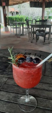 Doğayla çevrili bir restoranda ahşap bir masada iç.