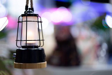 Lamba salonda ışıkların altında asılıydı..