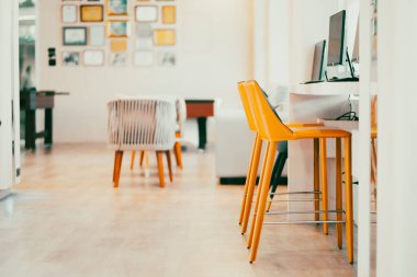 A bright yellow padded chair for typing in the computer in the internet room.