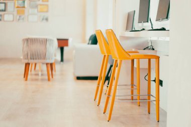 A bright yellow padded chair for typing in the computer in the internet room.