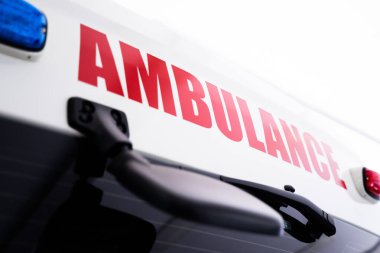 Kırmızı harfli beyaz ambulansın arka görüntüsü.
