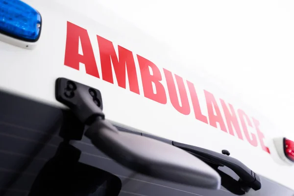 stock image Back view of white ambulance with red lettering.