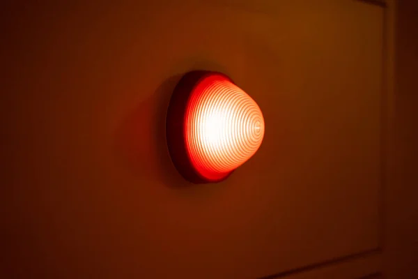 A red light bulb glowed on the side wall of the room.