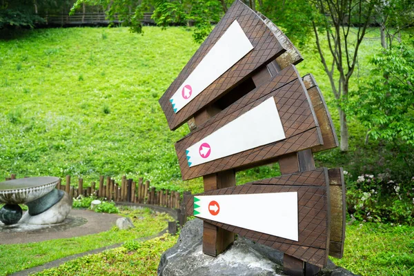 Wooden signposts with arrows pointing to different parts of the hotel