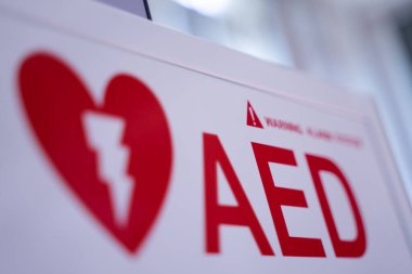 Beyaz bir kutuda bulunan otomatik dış defibrilatör (AED), kalp krizi geçiren insanlar için acil durum defibrilatörüdür..