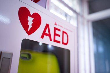 Beyaz bir kutuda bulunan otomatik dış defibrilatör (AED), kalp krizi geçiren insanlar için acil durum defibrilatörüdür..