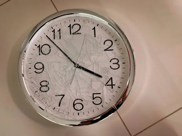 A clock with cracked and shattered glass lay on the floor.