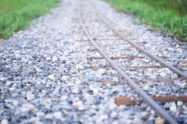Çakıl taşlarındaki küçük demiryolu raylarına yakın çekim.