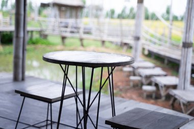 Yuvarlak ahşap masa ve ahşap sandalyeler. Sabah kahve yudumlamak için. Yeşil pirinç tarlası arka planı bulanık..