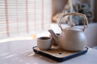 Çaydanlık ve çay fincanı, masaya konmuş çay seti, bulanık arka plan, sabah ışığı..