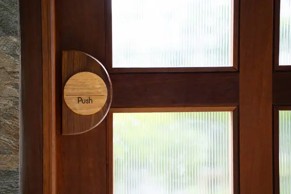 Restaurant door handle with push sign on classic wooden door.