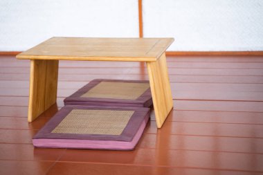 Japon tarzı oturma odasında yastıklı ahşap masa..