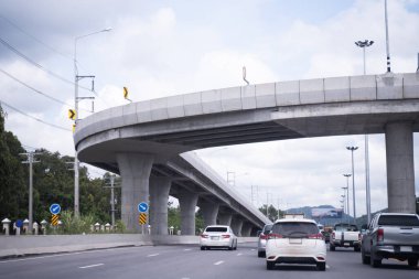 Otoyolda ve öğleden sonra gökyüzünün altındaki köprüde seyahat ediyorum..