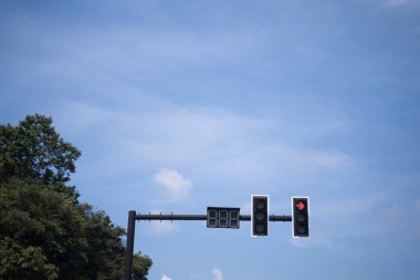 Parlak mavi gökyüzü arka planında trafik ışıkları.