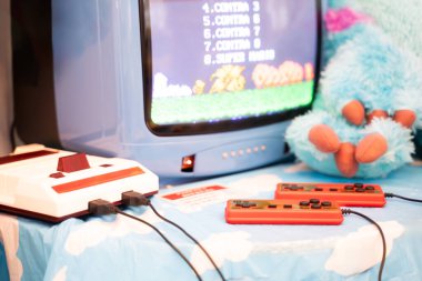 Masada eski oyun konsolları, video oyunu ekranı, retro TV seti ve joystick.