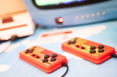 Eski bir joystick 'in yakın görüntüsü. Masanın üzerine yan yana yerleştirilmiş 80 'lerin oyunları.