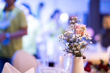 Bir otel ziyafetinde yemek masasında vazo..