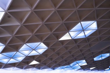 Modern tasarım otel seminer odasının aydınlatılmış tavanında geometrik bir üçgen var..