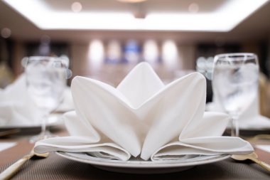 Yemek masasının üzerinde güzelce katlanmış beyaz bir peçete..