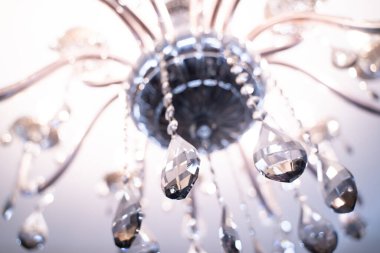 Çağdaş bir avizenin kristaline yakın plan, bir tavan ya da duvara monte edilecek dekoratif bir aydınlatma armatürü.