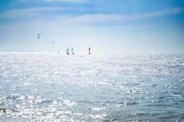 Rüzgar sörfçüleri güneşli yaz aylarında dalgalarda sörf yapmayı severler..