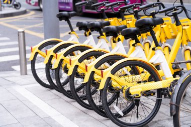 Belirlenmiş bir alana güzel sarı bir bisiklet park edilmiştir. Şehrin göbeğinde yol kenarında..