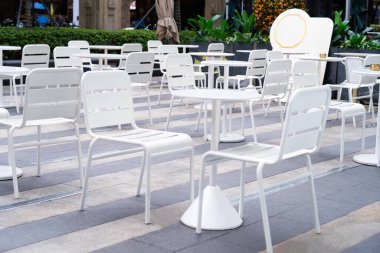 Minimalist bir dükkanda sandalyeli beyaz yemek masası. Açık hava yemek konsepti.