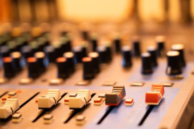 Müzik karıştırıcı kontrol panelinin yakın çekimi. Renkli düğmeler Arkaplan bulanıklaştırma tekniği kullanır.