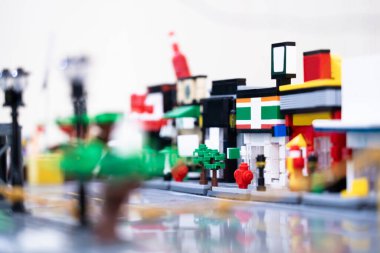 Bina yapıları ve şehirler olarak tasarlanmış renkli plastik bloklar. , bulanık ışık arka planında.