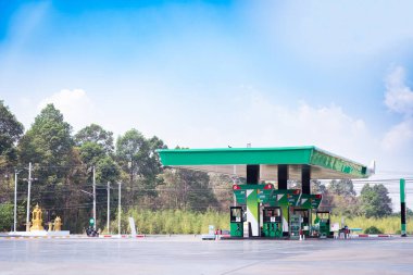 Bulutlu, gökyüzü ve güneş ışığıyla benzin istasyonu size hizmet etmeye hazır..