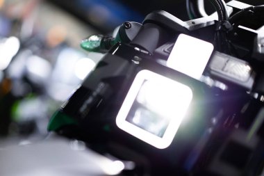Elektrikli motosiklet modern teknolojisinin ön görüntüsü çevre dostu belirli bir noktaya odaklanır arka plan bokeh ışığı üzerine.