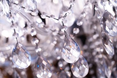 Çağdaş bir avizenin kristaline yakın plan, bir tavan ya da duvara monte edilecek dekoratif bir aydınlatma armatürü.