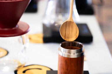 Tahta bir kaşığa yakın plan kahve çekirdeklerini tahtadan bir kavanoza dolduruyor..