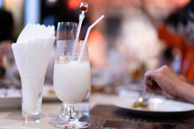 Yemek saatinde masada pipetle kokteyl bardağında soğuk yoğurt içeceği..