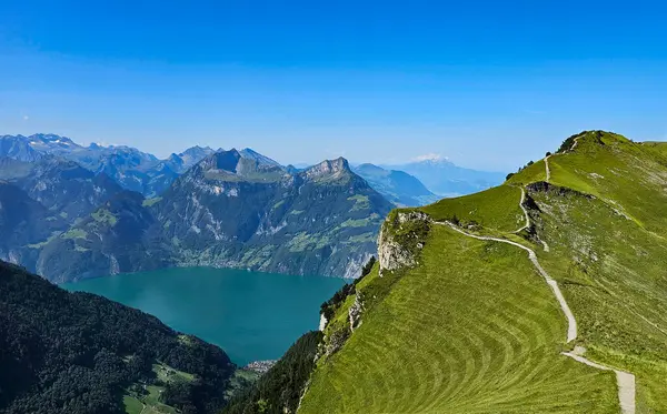 İsviçre Alpleri 'nin görkemli manzarasında yürüyüş yolu, yemyeşil yemyeşil ve pitoresk bir göl var..